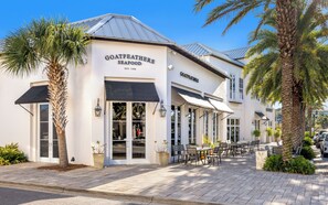 Een visrestaurant met terras en palmbomen.