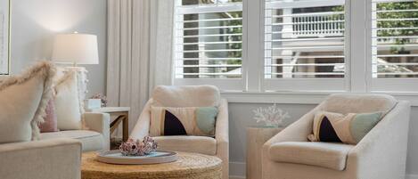 A living room with two armchairs, a round coffee table, and a lamp.