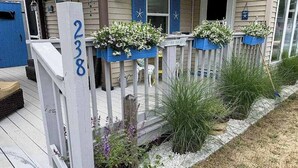 A house with a number 238 on the porch, blue shutters, and flower planters. - Coastal cottage close to sandy beach with private deck, kayaks & dog friendly (Dennis Port)