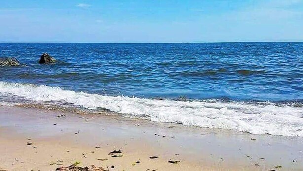 A beach with clear blue water, a sandy shore, and a rock formation in the distance. - Coastal cottage close to sandy beach with private deck, kayaks & dog friendly (Dennis Port)