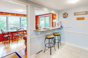 A kitchen with a window, a clock, and a sign on the wall. - Private house close to beach with grill, AC, yard, and deck (Yarmouth)