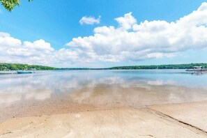 A wide river with boats, clear skies, and distant greenery. - Luxe lakefront home on Follins Pond with private beach, amazing decks & yard (Yarmouth Port)