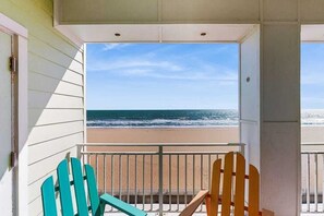 A balcony with a view of the beach and ocean. - Stunning oceanfront condo with panoramic views, balcony, pool, gym & AC (Virginia Beach)