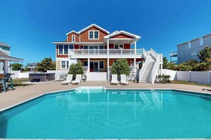 Ein zweigeschossiges Haus mit Pool, einem Balkon und einer Treppe, die zum Obergeschoss führt.
