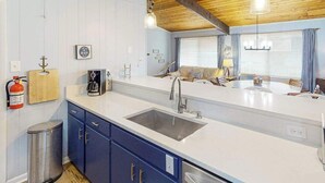 A kitchen with a sink, cabinets, a coffee maker, and a fire extinguisher. - Remodeled, ocean view home with rooftop deck & fast WiFi - dog-friendly (Virginia Beach)