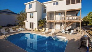 Un bâtiment à deux étages doté d  ’une piscine, d’un espace extérieur aménagé et d’un patio couvert.