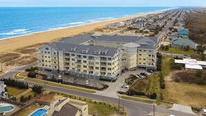 A multi-story hotel with a pool, located near a beach and ocean. - Oceanfront, corner condo with wrap-around deck, great views & on-site pool/gym (Virginia Beach)