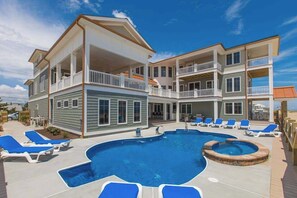 A two-story building with a swimming pool, lounge chairs, and a hot tub. - Wonderful beachfront home w/private indoor & outdoor pools, WiFi, AC, deck (Virginia Beach)