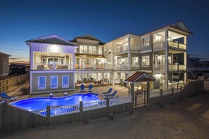 Ein mehrstöckiges Haus mit Pool, Sitzgelegenheit im Freien und einer Terrasse.