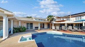 A swimming pool with lounge chairs and a covered patio area. - 8 BDR & 7.5 BA Luxury Beach House w/private pool & hot tub (Virginia Beach)