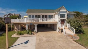 A two-story house with a covered front porch, a garage, and a small deck. - 8 BDR & 7.5 BA Luxury Beach House w/private pool & hot tub (Virginia Beach)