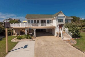 A two-story house with a covered front porch, a garage, and a small deck. - 8 BDR & 7.5 BA Luxury Beach House w/private pool & hot tub (Virginia Beach)