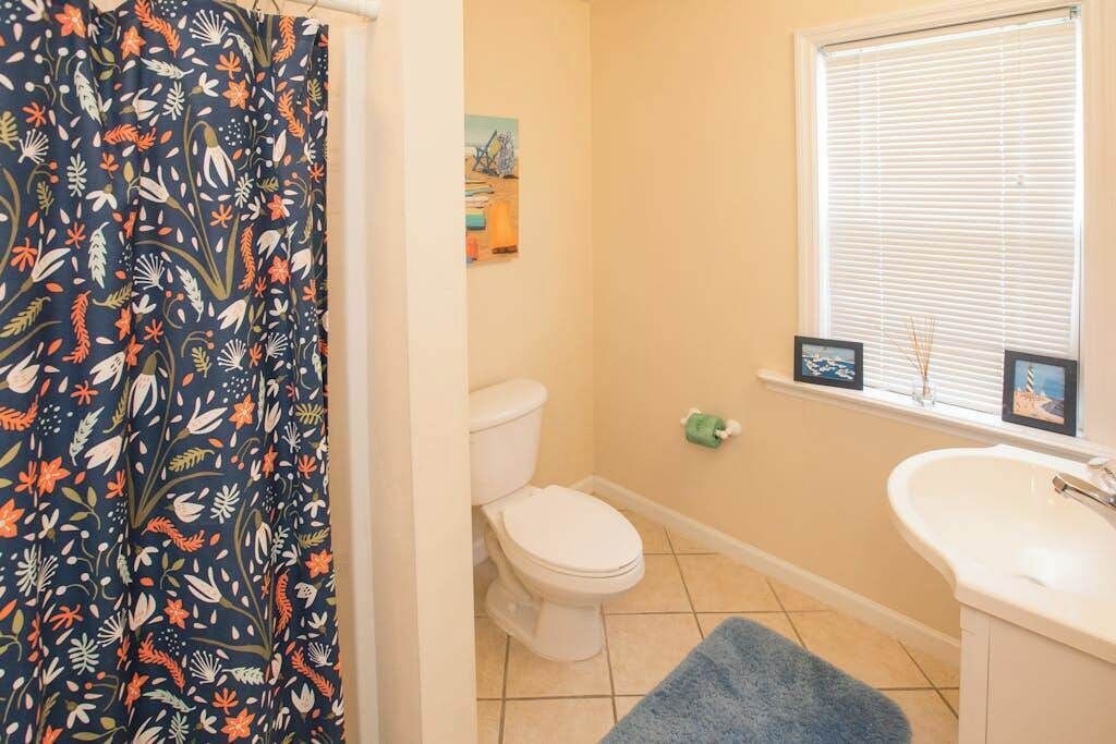 Een badkamer met toilet, wastafel en luxaflex.