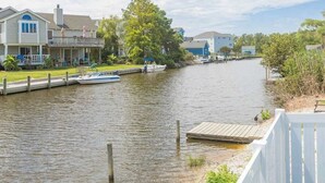 Une propriété située au bord de la rivière, dotée d’un quai, d’un bateau et de maisons le long du rivage.