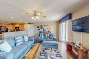 A living room with a sofa, a coffee table, and a TV. - Sunny Condo w/Shared Outdoor Pool, Central A/C, Private W/D - Near the Ocean (Virginia Beach)