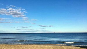 Una playa con cielos despejados y agua tranquila.