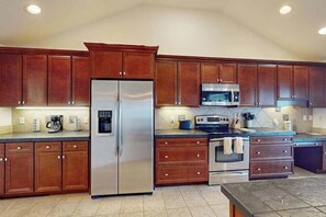 A kitchen with wooden cabinets, a stainless steel refrigerator, a microwave, an oven, and a coffee maker. - Waterfront house in Virginia Beach with amazing views, private pool & Hot Tub (Virginia Beach)