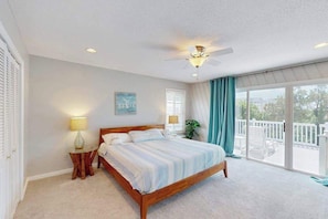 A bedroom with a bed, a ceiling fan, a window with curtains, and a balcony. - Fantastic home with private pool, hot tub, Ping-Pong, billiards & fast WiFi (Virginia Beach)