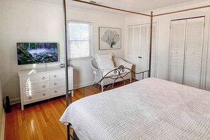 A bedroom with a bed, a dresser, a television, and a window. - Sweet Home Near Croatan Beach & Boardwalk with Deck, WiFi, Bikes - 2 Dogs OK (Virginia Beach)