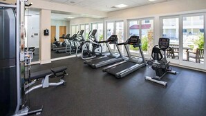 A gym with treadmills, a bench press, and a weight machine. - Inviting condo steps from the beach with balcony & resort pools (Virginia Beach)