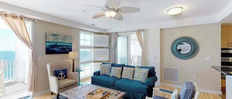 A living room with a sofa, coffee table, and a ceiling fan.