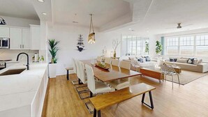A modern interior with a dining area, kitchen, and living space. - Oceanfront condo with gorgeous views, fast WiFi, washer/dryer, on-site pool/gym (Virginia Beach)