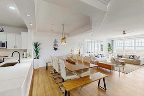 A modern interior with a dining area, kitchen, and living space. - Oceanfront condo with gorgeous views, fast WiFi, washer/dryer, on-site pool/gym (Virginia Beach)