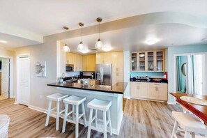 A modern kitchen with a central island, bar stools, pendant lighting, and built-in cabinetry. - Awesome home overlooking Back Bay with pool, washer/dryer & central AC (Virginia Beach)