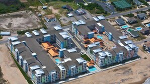 Ein Küstenhotel mit mehreren Gebäuden, einem Strand und einer Straße.