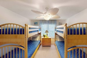 A room with bunk beds, a ceiling fan, a bedside table with a lamp, and a window with blinds. - Beautiful home close to the Atlantic w/shared pool, private washer/dryer, WiFi (Virginia Beach)