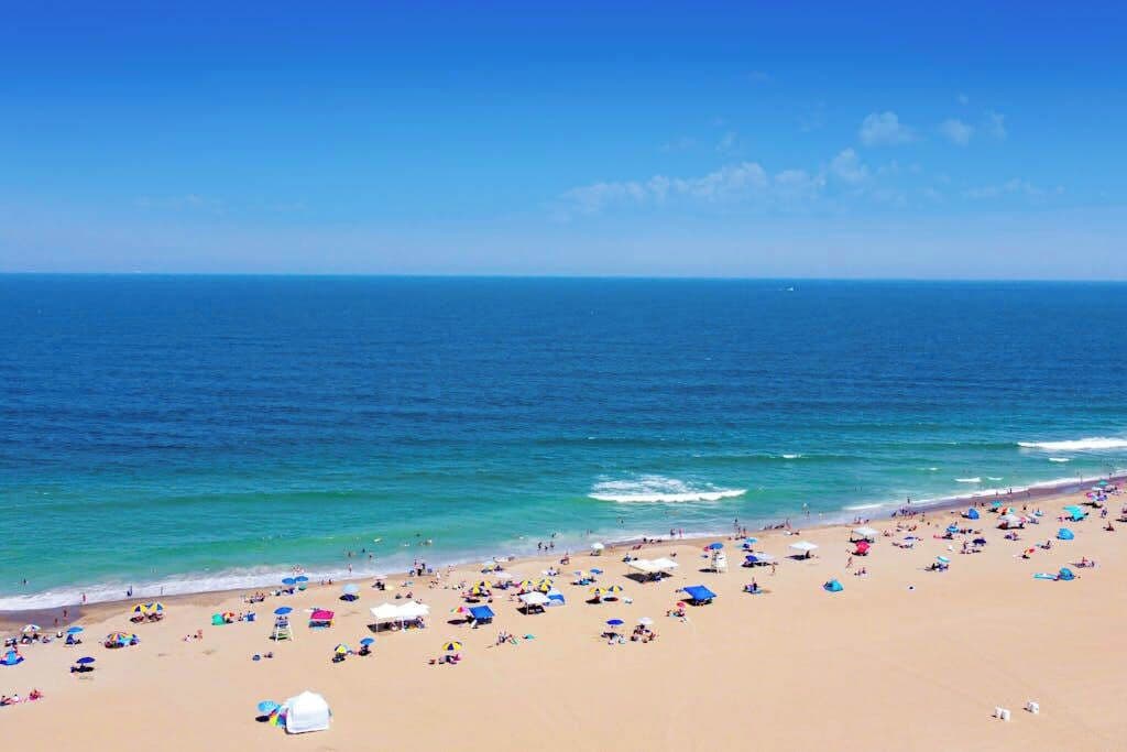 A beach with a wide sandy area and a clear blue sea.