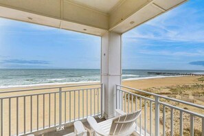 A balcony with a view of the beach and ocean. - Oceanfront corner condo with wraparound balcony, 3 pools, gym, & views (Virginia Beach)
