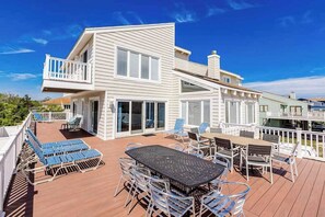 A two-story house with a deck, outdoor furniture, and a white railing. - Lovely, contemporary home w/private pool/hot tub, easy beach access, central AC (Virginia Beach)