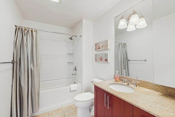 Ein Badezimmer mit Dusche, Toilette, Waschbecken und Waschtisch.