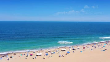 Una playa con una amplia zona de arena y un mar azul transparente.