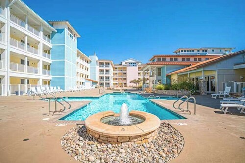 Sunlit single-level condo with pool, washer/dryer, central AC, & balcony