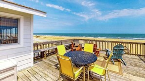 A wooden deck with a round table and chairs, overlooking a beach. - Oceanfront home w/private pool, beautiful views, WiFi, central AC, private W/D (Virginia Beach)