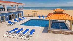 A pool area with lounge chairs, a small pool, and a beach view. - Oceanfront vacation gem w/private indoor & outdoor pools, WiFi, central AC, W/D (Virginia Beach)