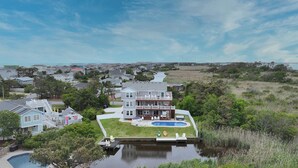A large house with a pool, surrounded by greenery and a river. - 9BR home with private pool, hot tub & 4 min to beach, free WIFI (Virginia Beach)