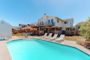 A two-story house with a swimming pool, a covered deck, and a fenced backyard. - Dog-friendly home with private pool, fenced yard, ocean view, nice deck & WiFi (Virginia Beach)