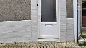 A white door with a small window, a metal handle, and a peephole.