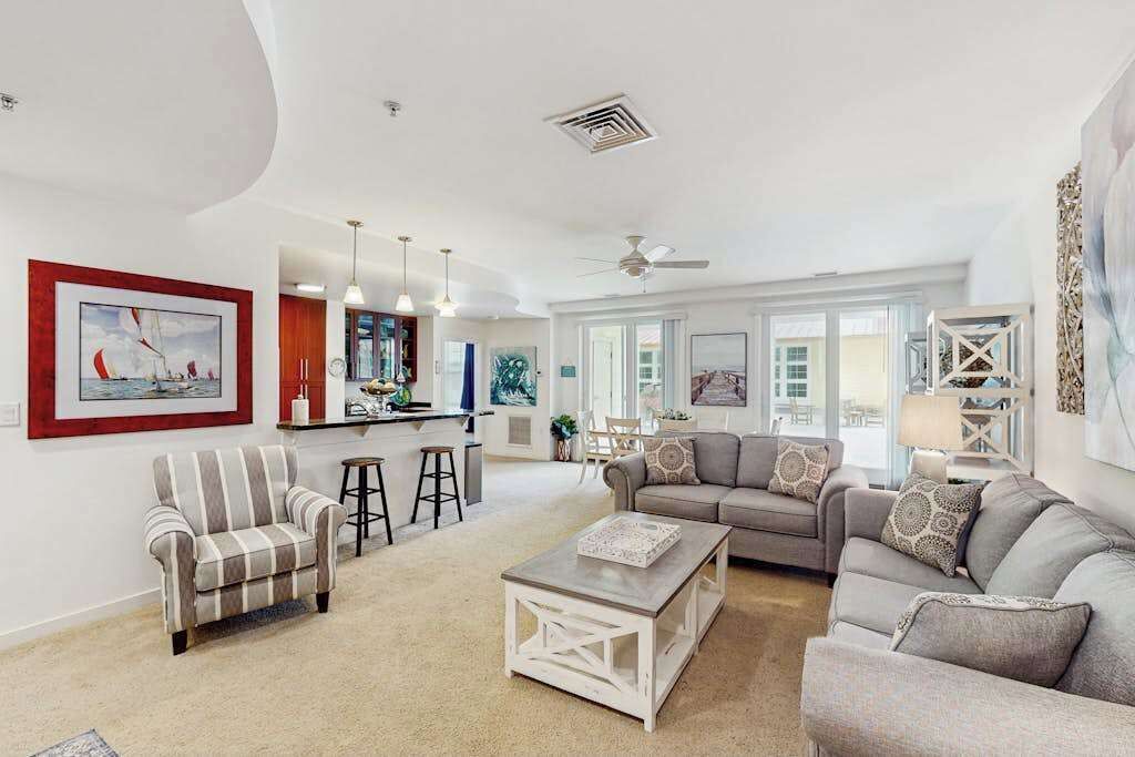 A spacious living room with a sofa, armchairs, a coffee table, and a dining area with chairs and a table.