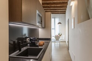 A modern kitchen with a built-in microwave, stainless steel sink, and a wooden ceiling. - Cesariano, 11 - Downtown - Park & Movida (Milan)
