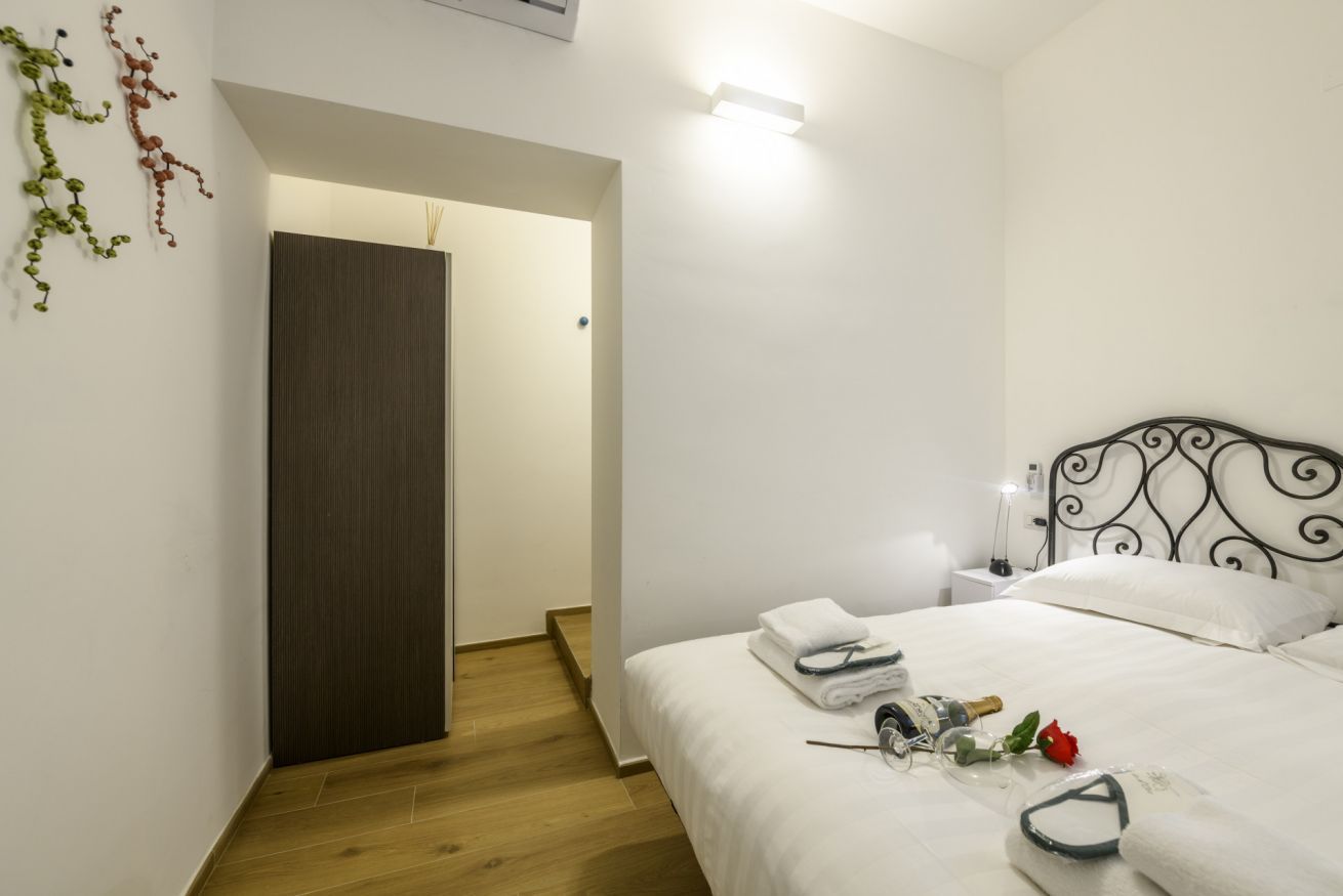 Une chambre à coucher avec un lit, une table de chevet et une petite table de nuit avec une lampe.
