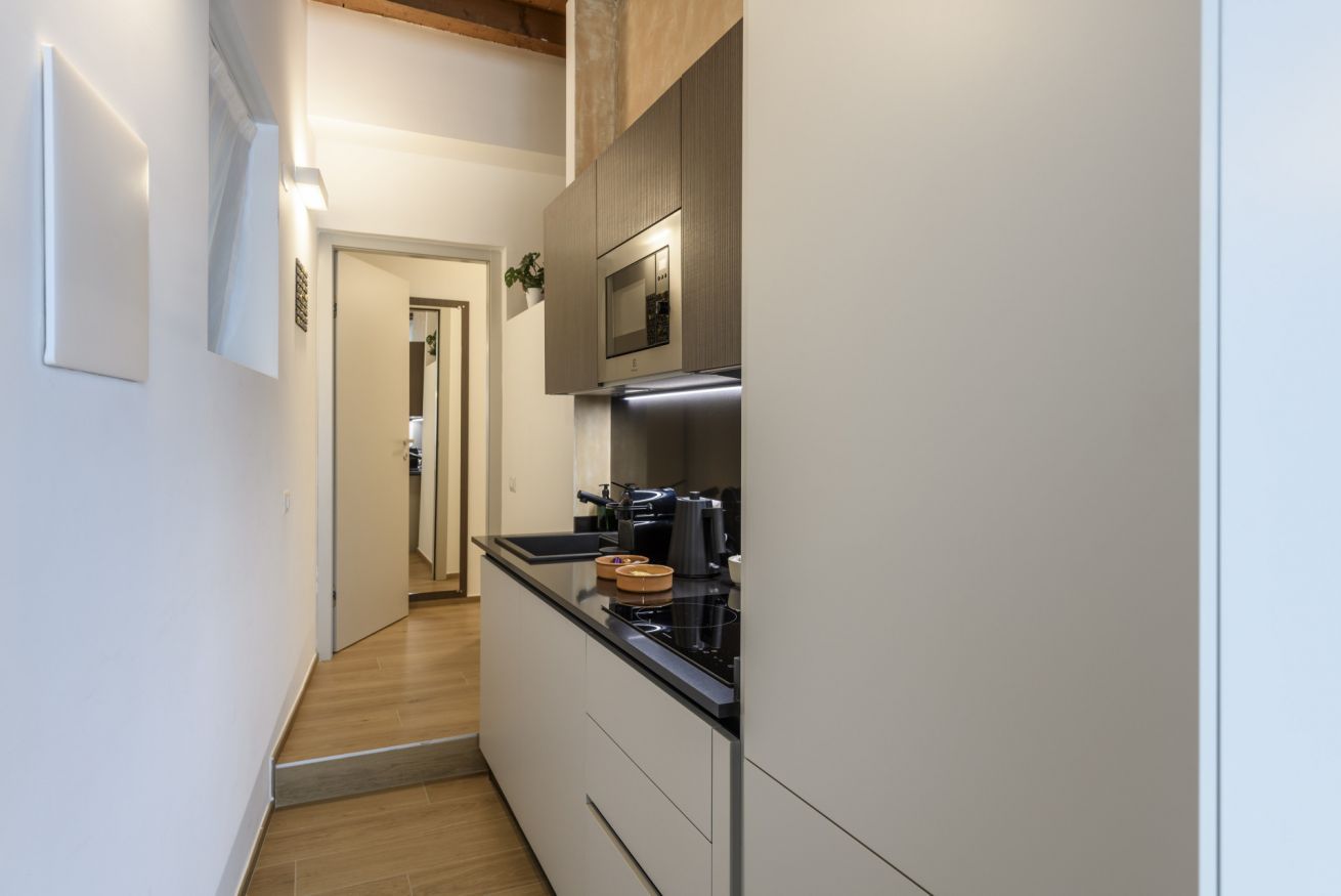 A narrow kitchen with a microwave, stove, and cabinets.