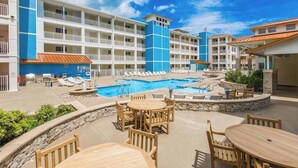 Un hôtel doté d’une piscine, de plusieurs balcons et d’un espace extérieur aménagé pour s’asseoir.