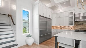A modern kitchen with white cabinetry, a stainless steel refrigerator, and a marble island. - 🐚Private Pool | Golf Cart | Steps to Beach | Gulf Views | 30A All Day (Santa Rosa Beach)