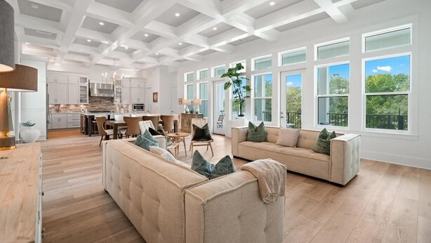 A spacious living area with a high ceiling, large windows, and a modern kitchen in the background. - 🐚Private Pool | Golf Cart | Steps to Beach | Gulf Views | 30A All Day (Santa Rosa Beach)