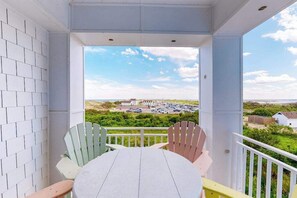 A balcony with a table and chairs, a view of a parking lot and buildings, and a clear sky. - Great condo with 2 balconies, excellent ocean & bay views, 3 pools, & gym (Virginia Beach)