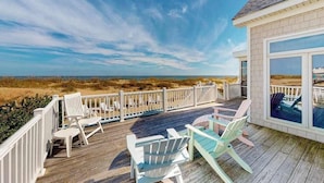 A wooden deck with outdoor seating, a white fence, and a view of the beach and ocean. - Fantastic oceanfront home w/private pool & hot tub, WiFi, central AC, & deck (Virginia Beach)